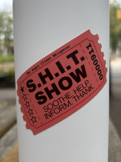 A white metal water bottle with a red ticket-style sticker that reads “S.H.I.T. Show - Soothe, Help, Inform, Thanks." 